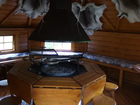 L’intérieur en bois du chalet et son foyer central