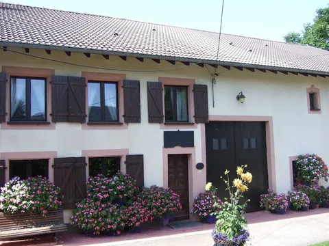 La façade du Gîte Les Fleurs et ses fleurs roses